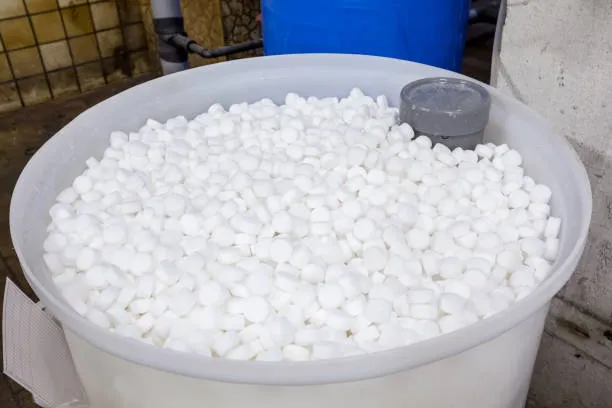 A water softener brine tank filled with salt pellets, with the float assembly visible inside.
